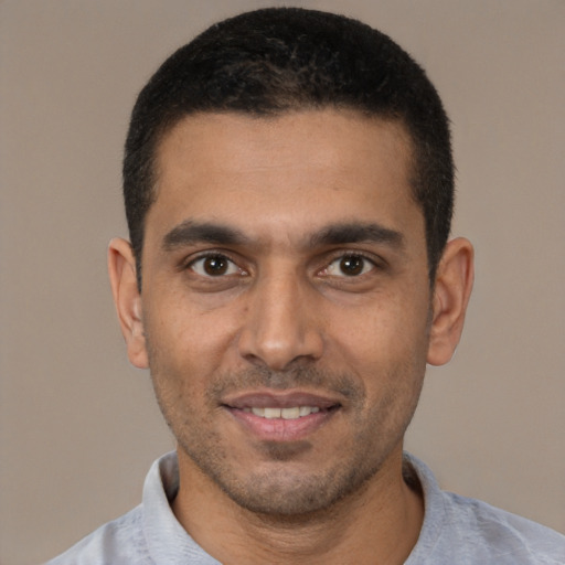 Joyful white young-adult male with short  black hair and brown eyes