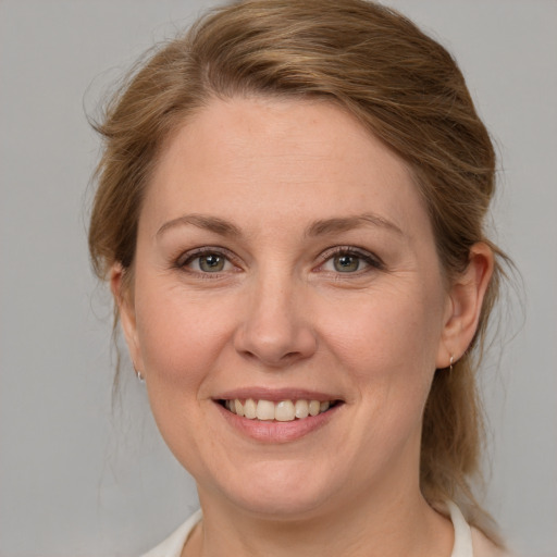 Joyful white adult female with medium  brown hair and grey eyes