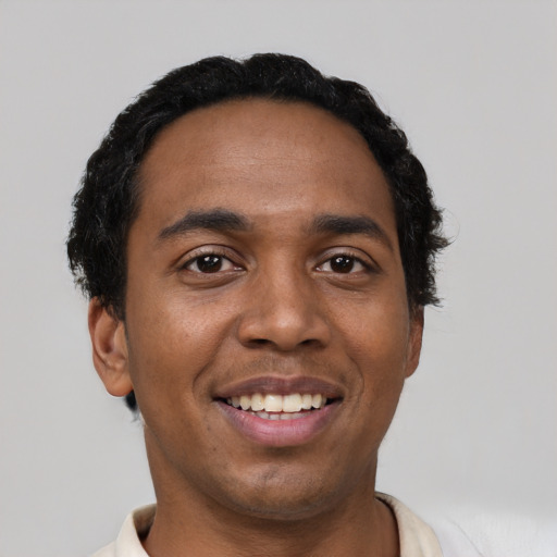 Joyful black young-adult male with short  black hair and brown eyes