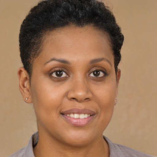 Joyful black young-adult female with short  brown hair and brown eyes