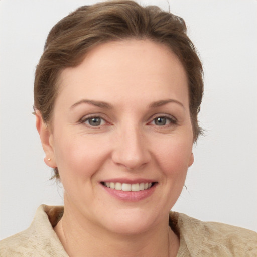 Joyful white young-adult female with medium  brown hair and grey eyes