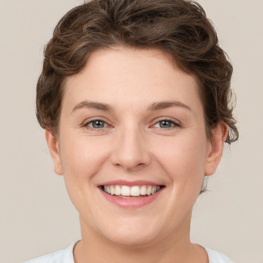 Joyful white young-adult female with short  brown hair and green eyes