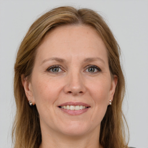 Joyful white adult female with long  brown hair and grey eyes