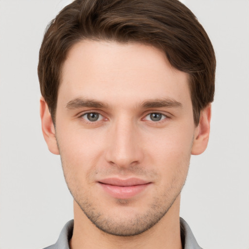 Joyful white young-adult male with short  brown hair and grey eyes