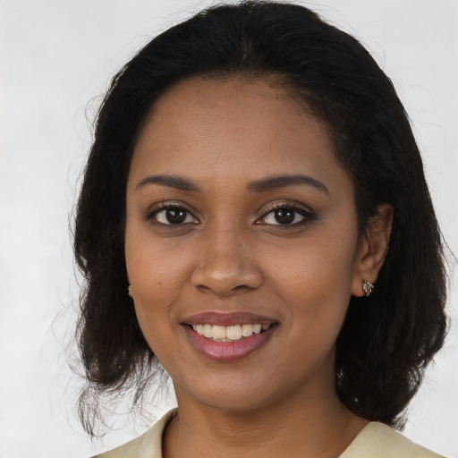 Joyful black young-adult female with long  brown hair and brown eyes