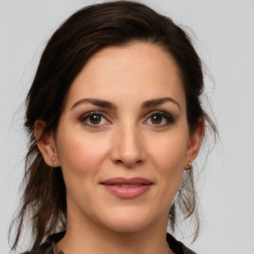 Joyful white young-adult female with medium  brown hair and green eyes