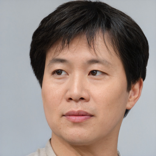 Joyful asian adult male with short  brown hair and brown eyes