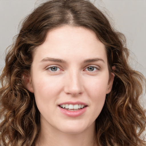 Joyful white young-adult female with long  brown hair and green eyes