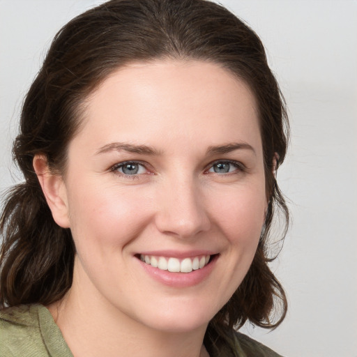 Joyful white young-adult female with medium  brown hair and grey eyes