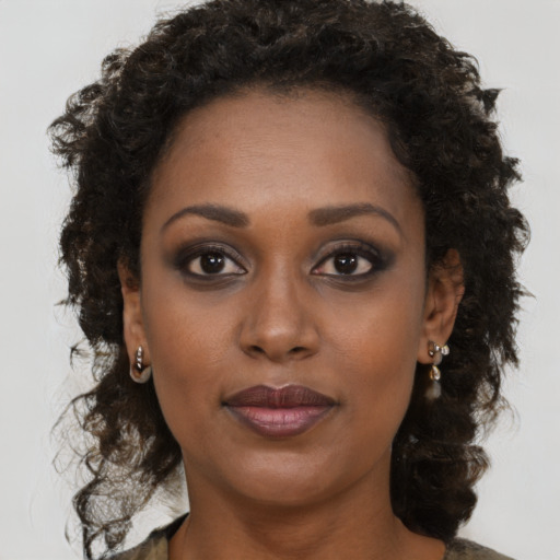 Joyful black young-adult female with medium  brown hair and brown eyes