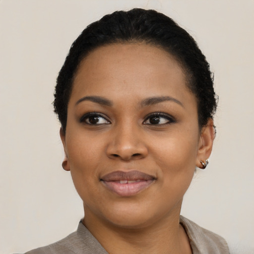 Joyful black young-adult female with short  black hair and brown eyes