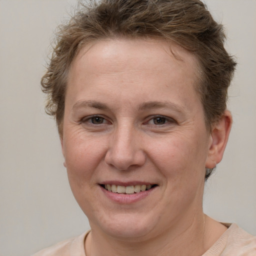 Joyful white adult female with short  brown hair and grey eyes