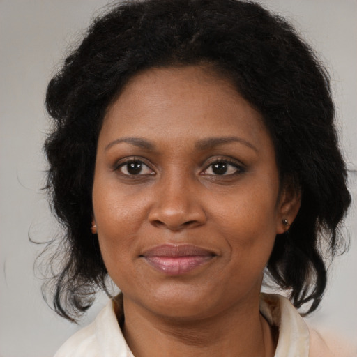 Joyful black adult female with medium  brown hair and brown eyes