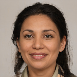 Joyful latino adult female with medium  brown hair and brown eyes