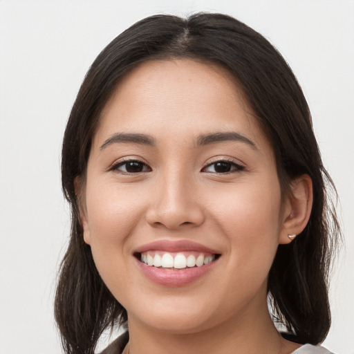 Joyful white young-adult female with long  brown hair and brown eyes