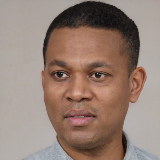 Joyful black adult male with short  black hair and brown eyes