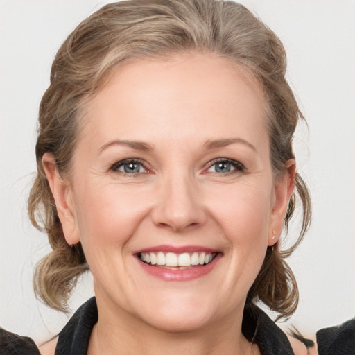 Joyful white adult female with medium  brown hair and grey eyes