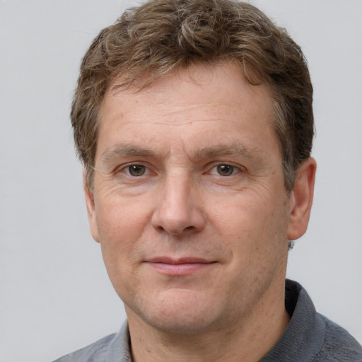 Joyful white adult male with short  brown hair and grey eyes