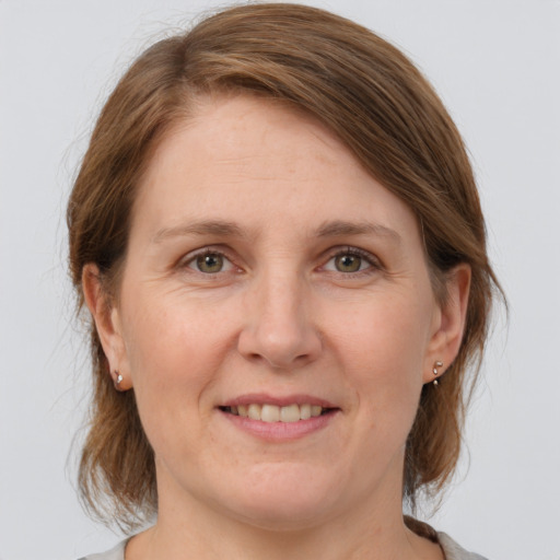 Joyful white adult female with medium  brown hair and grey eyes