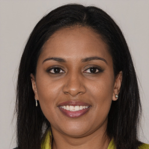 Joyful black young-adult female with long  brown hair and brown eyes