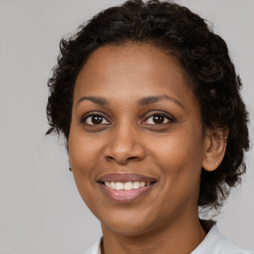 Joyful black young-adult female with medium  brown hair and brown eyes