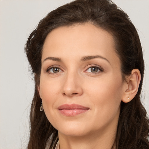 Joyful white young-adult female with long  brown hair and brown eyes