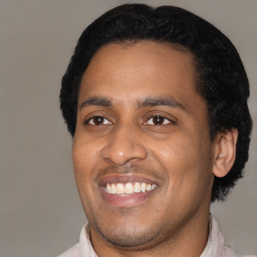 Joyful latino young-adult male with short  black hair and brown eyes