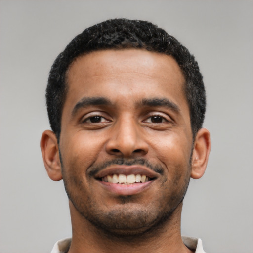 Joyful latino young-adult male with short  black hair and brown eyes