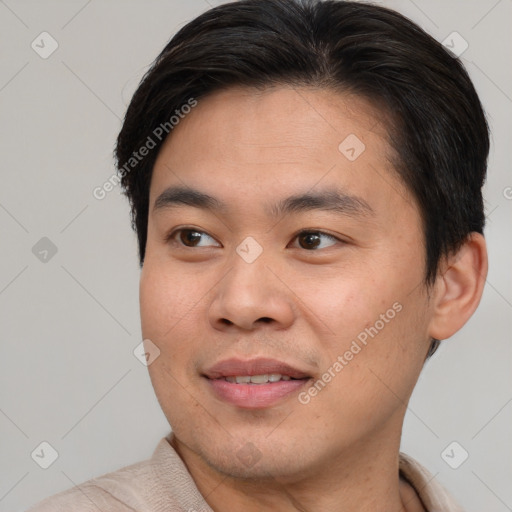 Joyful asian young-adult male with short  brown hair and brown eyes