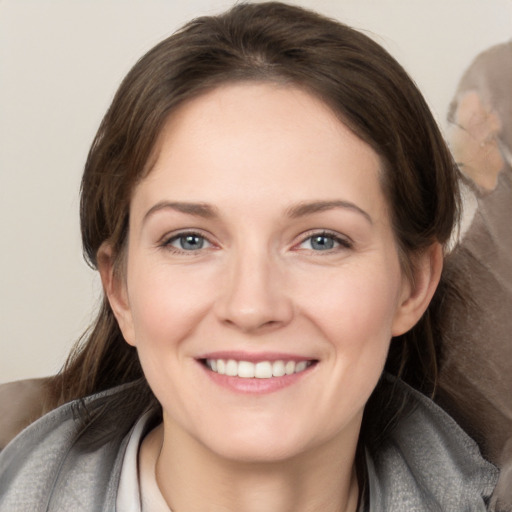 Joyful white young-adult female with medium  brown hair and grey eyes