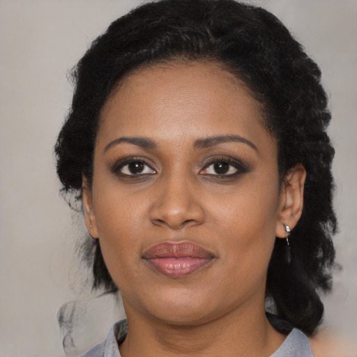 Joyful black young-adult female with medium  black hair and brown eyes