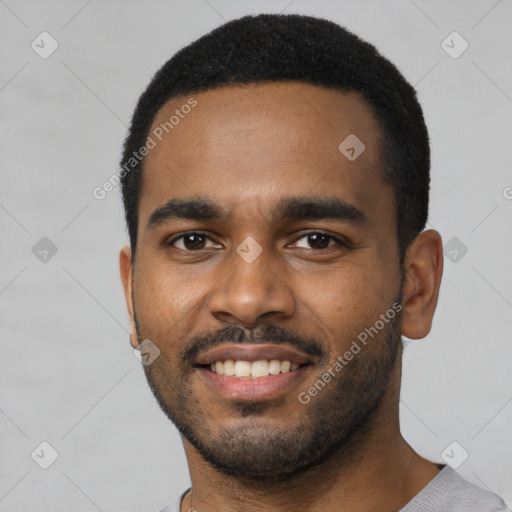 Joyful black young-adult male with short  black hair and brown eyes