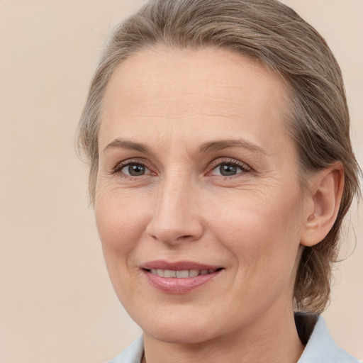 Joyful white adult female with medium  brown hair and grey eyes