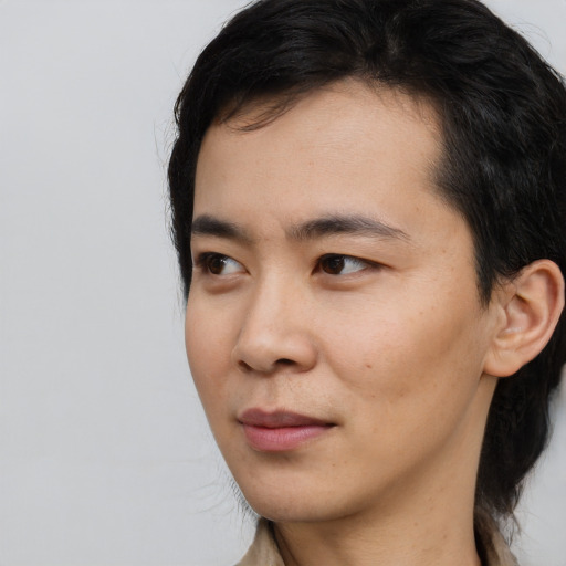 Joyful asian young-adult male with long  black hair and brown eyes