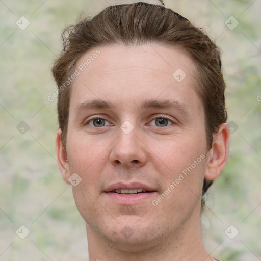 Joyful white young-adult male with short  brown hair and grey eyes