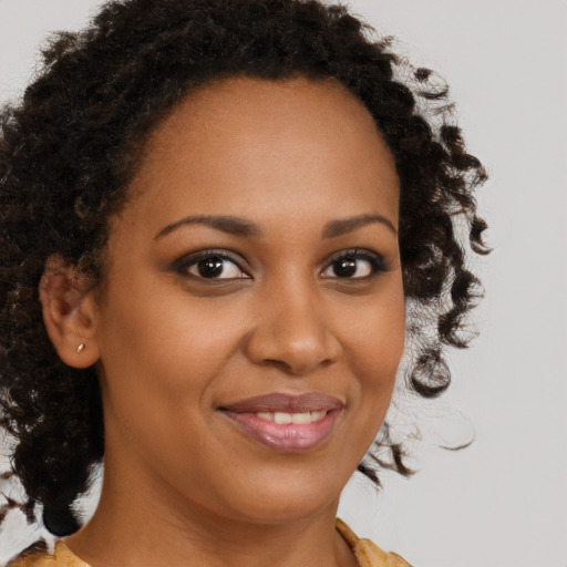 Joyful black young-adult female with medium  brown hair and brown eyes