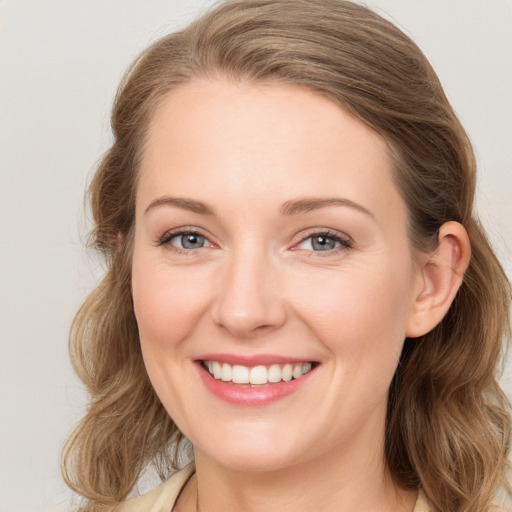 Joyful white young-adult female with long  brown hair and blue eyes