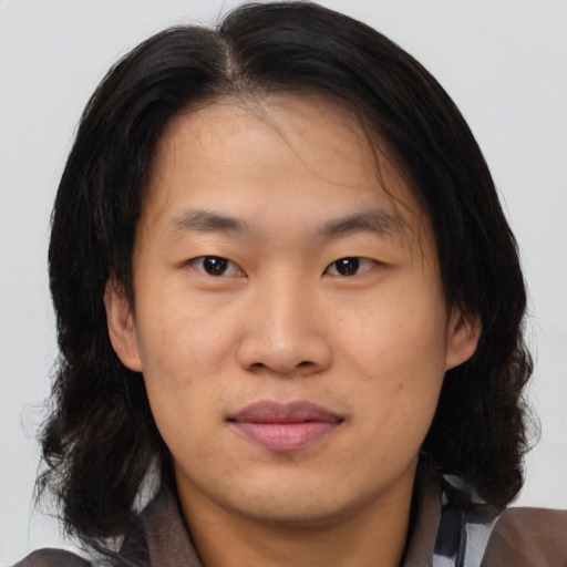 Joyful asian young-adult male with medium  brown hair and brown eyes