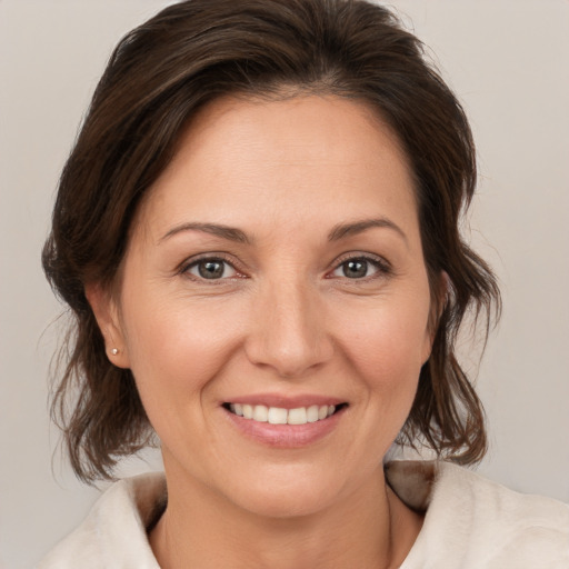 Joyful white adult female with medium  brown hair and brown eyes