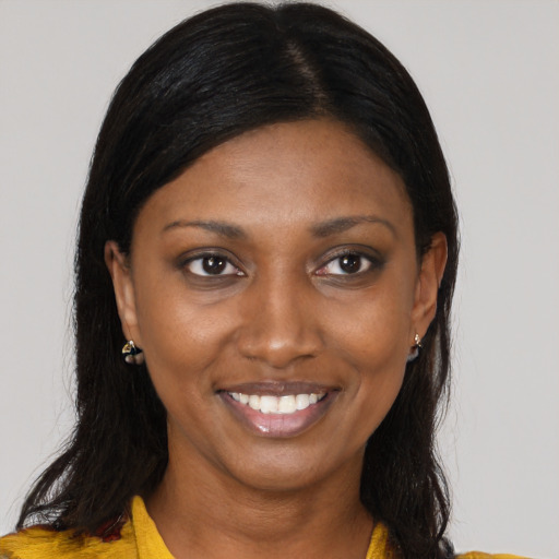 Joyful black young-adult female with long  brown hair and brown eyes