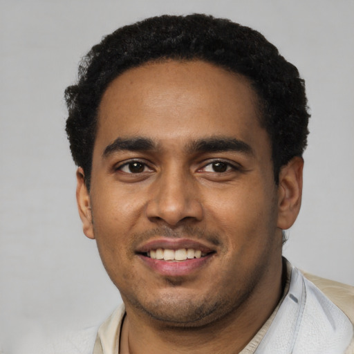 Joyful black young-adult male with short  black hair and brown eyes