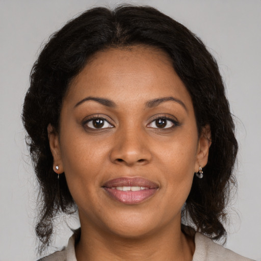 Joyful black adult female with medium  brown hair and brown eyes