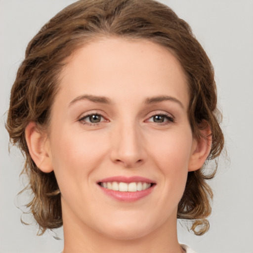 Joyful white young-adult female with medium  brown hair and green eyes