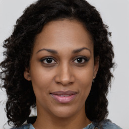 Joyful black young-adult female with long  brown hair and brown eyes