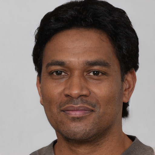 Joyful latino adult male with short  black hair and brown eyes