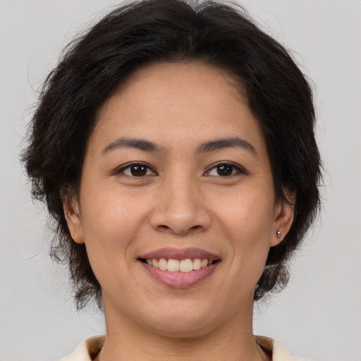 Joyful latino young-adult female with medium  brown hair and brown eyes