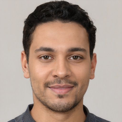 Joyful latino young-adult male with short  black hair and brown eyes