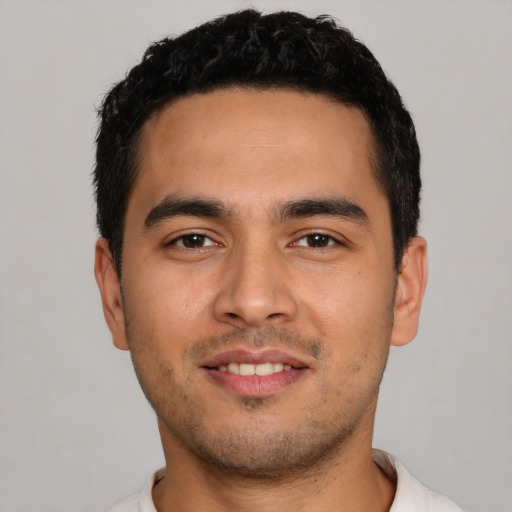 Joyful latino young-adult male with short  black hair and brown eyes