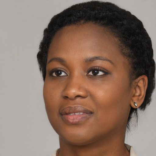 Joyful black young-adult female with short  black hair and brown eyes