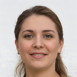 Joyful white young-adult female with long  brown hair and grey eyes